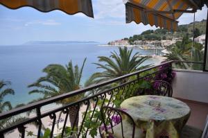 a balcony with a table and a view of the ocean at Villa DELFINA in Podgora