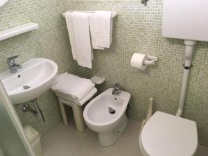 a bathroom with a white toilet and a sink at Hotel Laila in Cesenatico