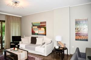 salon z białą kanapą i żyrandolem w obiekcie Amazing Apartment w Atenach
