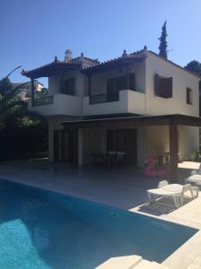 a house with a swimming pool in front of it at Villa Harmony, Porto Heli in Porto Heli