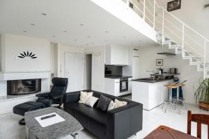 a living room with a black couch and a kitchen at Ferienwohnung Seerhein in Konstanz