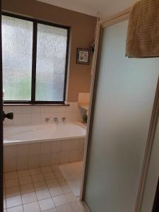 a bathroom with a bath tub and a window at Abbey Beach Cottage in Busselton