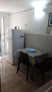una cucina con tavolo e frigorifero bianco di Pochi passi dal mare a San Pietro in Bevagna