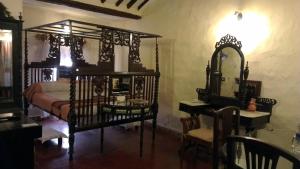 a bedroom with a bed and a mirror and a desk at Indeco Hotels Swamimalai in Kumbakonam