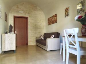 ein Wohnzimmer mit einem Sofa und einem Tisch in der Unterkunft Casa Vacanze Donna Lucia in Scoglitti