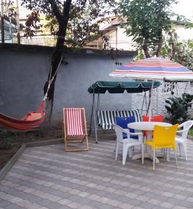 a patio with a table and chairs and an umbrella at Apartment 19 in Kutaisi