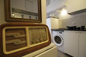 a kitchen with a microwave and a washing machine at Retro Art house in Rome