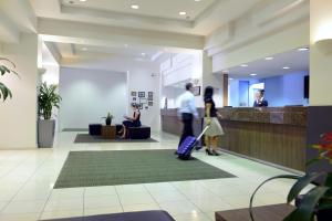 a couple of people with luggage in a lobby at Grosvenor Hotel Adelaide in Adelaide