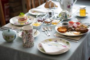 a table with plates of food and cups and spoons at Pontyclerc Farm House Bed and Breakfast in Ammanford