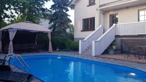 a swimming pool in front of a house at SAULES SVECIU NAMAI in Palanga