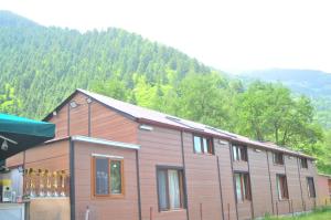 ein großes Holzhaus mit einem Berg im Hintergrund in der Unterkunft DİLEK SUIT&CAFE in Uzungöl