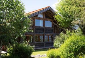 a log cabin with glass windows and trees at Chalet Chatel, avec services, Collection Chalets des Fermes - Megève in Megève