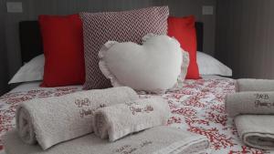 a bed with towels and a heart pillow on it at B&B Punta Stilo in Torre San Giovanni Ugento