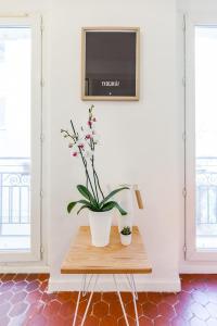 une table avec une plante en pot et une télévision dans l'établissement Le Moulin, à Marseille