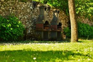a bird house sitting in the grass next to a tree at La Cabada in Ortiguero