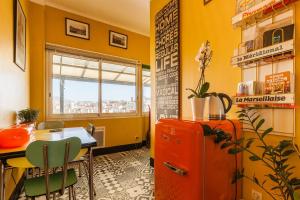 a yellow room with a table and a red refrigerator at Le Ptit Jaune- Terrasse sur le Vieux Port in Marseille