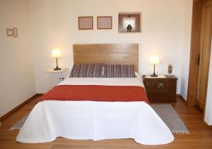 ヴァーレ・デ・カンブラにあるCasa da Eira Velhaのベッドルーム1室(大型ベッド1台、ランプ2つ付)