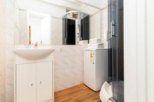 biała łazienka z umywalką i lustrem w obiekcie Apartments Gdańsk Dworska by Noclegi Renters w Gdańsku