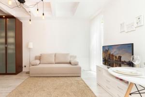 Biały salon z kanapą i telewizorem w obiekcie Apartments Gdańsk Dworska by Noclegi Renters w Gdańsku