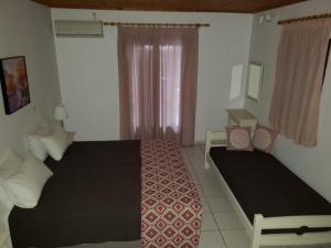 1 dormitorio con 2 camas y ventana en Marketos Apartments, en Svoronata