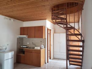 uma cozinha com uma escada em espiral num quarto em Marketos Apartments em Svoronata