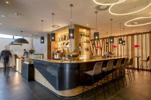 a bar in a restaurant with a counter and chairs at AKZENT Hotel Laupheimer Hof in Laupheim