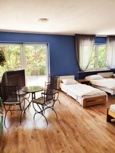 カトヴィツェにあるKatoHostelのベッド2台、テーブル、椅子が備わる客室です。