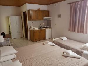 a room with two beds and a kitchen with at Marketos Apartments in Svoronata