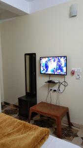 a living room with a flat screen tv on the wall at Jupiter Lodge in Siliguri