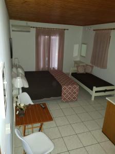 um quarto com uma cama, uma mesa e uma cadeira em Marketos Apartments em Svoronata