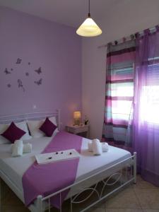 una camera da letto con un grande letto con pareti viola di Nikoletta Rooms a Paroikia