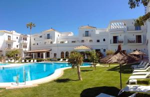 un gran edificio blanco con una gran piscina en Hotel Doña Lola Zahara en Zahara de los Atunes
