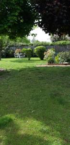 a lawn with a table and chairs in a yard at Chambre d'hote Chez Liz in Maslives