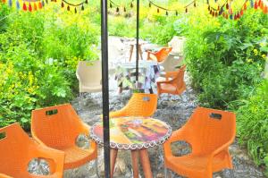 a patio with orange chairs and a table with an umbrella at 61 Dilek Pansiyon in Uzungöl