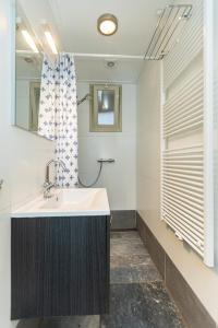 W łazience znajduje się umywalka i prysznic. w obiekcie Vakantiehuizen 7Huizen aan Zee w mieście Scharendijke