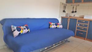 um sofá azul numa cozinha com duas almofadas em Dandy apartment #1 em Jezera