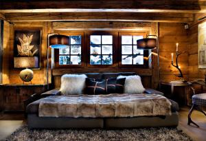 a bedroom with a bed in a room with wooden walls at Chalet des Fermes de Marie, avec services, Collection Chalets des Fermes in Megève