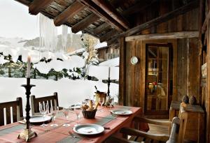 - une table en bois avec des assiettes et des verres à vin dans l'établissement Chalet des Fermes de Marie, avec services, Collection Chalets des Fermes, à Megève