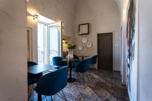 a dining room with blue chairs and a table at AL CONSOLE LUXURY SUITE in Monopoli