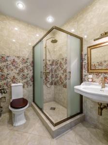 uma casa de banho com um chuveiro, um WC e um lavatório. em Bon Son Hotel and Hostel Центр em Voronezh