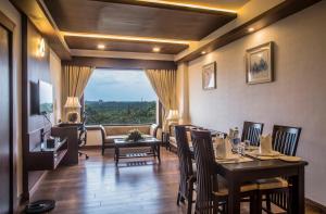 a dining room with a table and chairs and a couch at KPM TRIPENTA HOTEL in Kozhikode