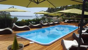 a swimming pool on a deck with chairs and umbrellas at Banjol 441 Apartman mare in Rab +6 photos