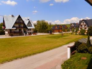 eine Gruppe von Häusern in einem Park mit Auffahrt in der Unterkunft Apartament Iskra in Zakopane