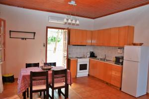 a kitchen with a table and chairs and a white refrigerator at Ithaki House in Vathi