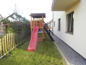 a red slide in a yard next to a house at Willa Basia in Ustronie Morskie