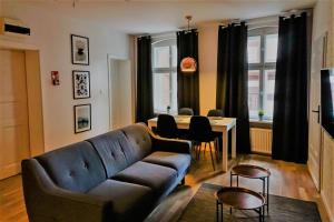 a living room with a couch and a table at Apartamenty toruńskie pod Krzywą Wieżą in Toruń