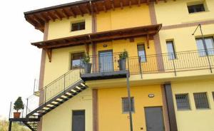 un bâtiment jaune avec un balcon orné de plantes. dans l'établissement Hotel Del Brembo, à Osio Sotto