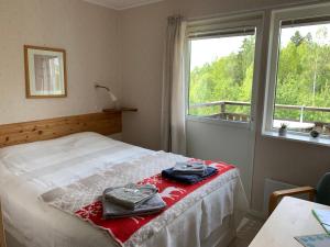 a bedroom with a bed with two towels on it at Kullerbacka Gästhus in Segersta