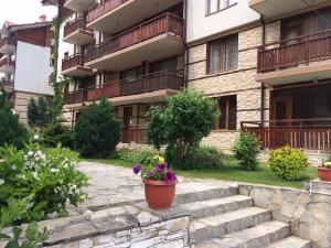 a building with stairs and flowers in a courtyard at Apartments Four Leaf Clover Bansko to rent in Bansko
