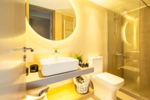 bagno con lavandino, servizi igienici e specchio di Luxury penthouse apartment near the city center a Heraklion
